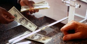 Bank teller counting money for customer